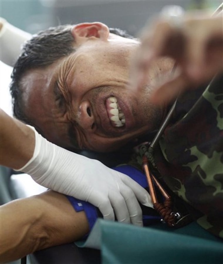Medical personnel examine an injured Thai soldier Thursday at a hospital following clashes between Thai and Cambodia froces in Surin province, northeastern Thailand.